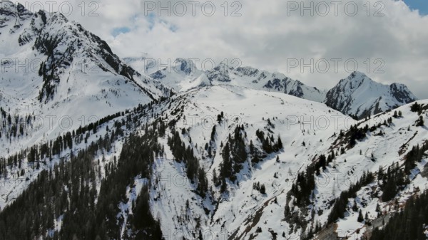 Aerial view of snow mountain range landscape with clouds. Alps mountains, Austria, Europe