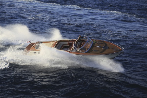 Aerial view sports boat J Craft 42 Torpedo R at full speed on the Cote d'Azur, luxury motorboat from the Swedish shipyard J Craft Boats with Volvo Penta engine in vintage style of the 50s and 60s in the style of the Riva boats, Mediterranean Sea