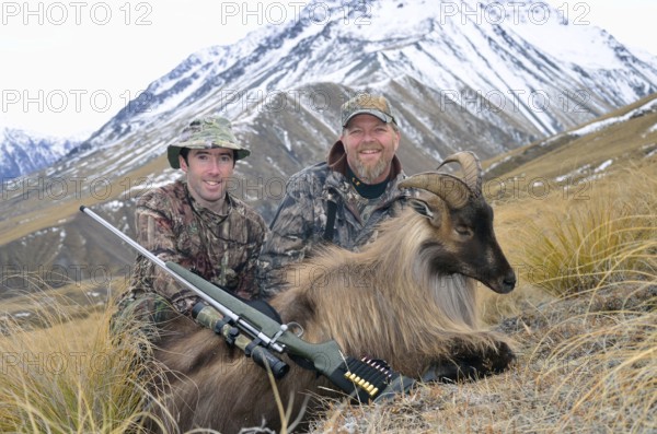 Hunters pose with their Himalayan tahr in the Southern Alps of New Zealand