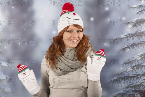 Portrait of woman in winter with snow and snowman hat