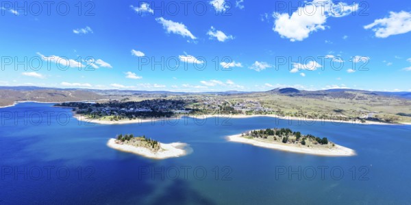 The view towards the town of Jindabyne over Lion and Cub Islands in Lake Jindabyne on a warm sunny summer's day in New South Wales, Australia, Oceania