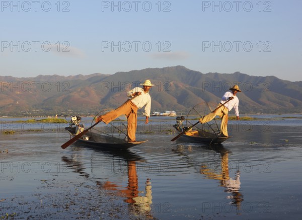 Myanmar travel attraction landmark, Traditional Burmese fishermen with fishing net at Inle lake in Myanmar famous for their distinctive one legged rowing style