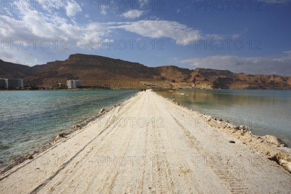 Sunset. Incredible lighting effects in a thunderstorm at the Dead Sea. The road in the middle of the sea