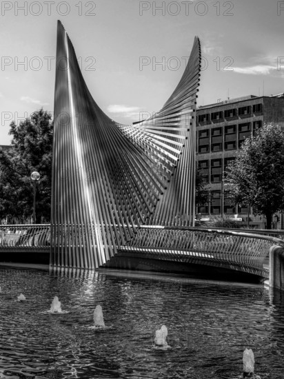 Modern steelwork in the municipal fountain, surrounded by buildings