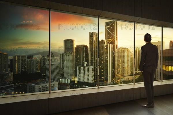 Geschäftsmann schauen und denken vor einem Fensterbüro mit moderner Stadt Skyline . Sunrise Szene