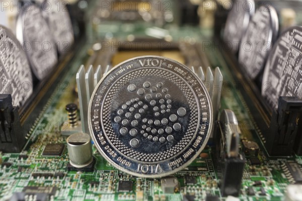 IOTA coin close-up on a computer circuit motherboard as a blockchain technology payment network. Digital cryptocurrency concept and mining
