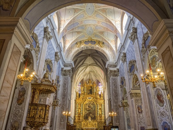 Magnificent interior of a baroque-style church with richly decorated altar and ceiling paintings illuminated by chandeliers, Dürnstein, Wachau, Danube, Austria, Europe