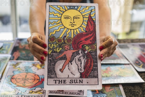 Close-up of the giant Tarot card The Sun held by the tarot reader