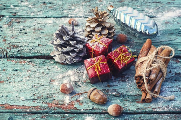 Christmas decorations, cone, cinnamon and nuts on wooden background