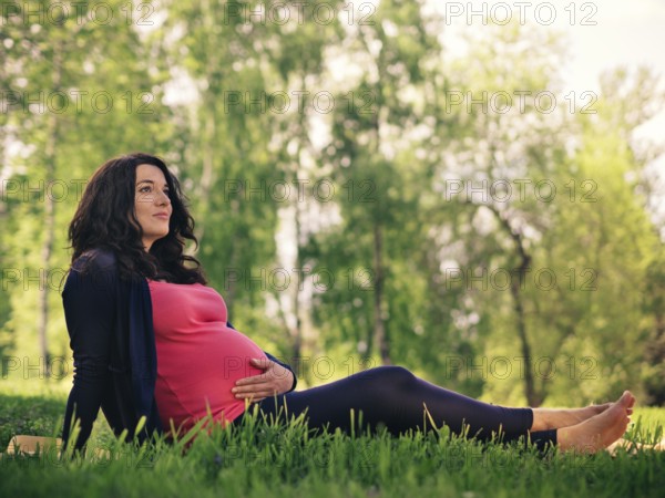 Beautiful pregnant woman relaxing in park