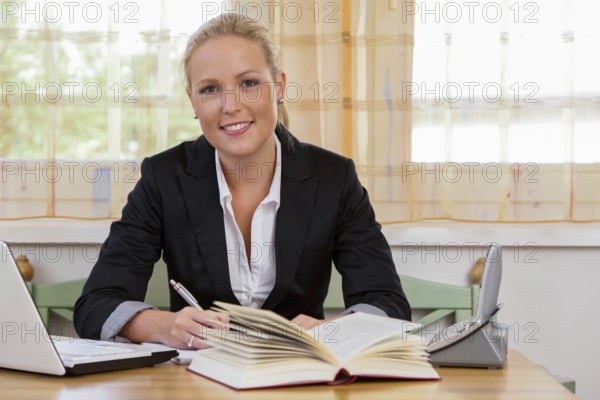 Successful young entrepreneur at her desk with Bruch and Laptop Computer Austria