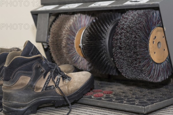 Hiking boots stand by a shoe shine machine
