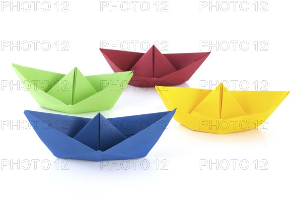 Colorful folded paper boats isolated over white background