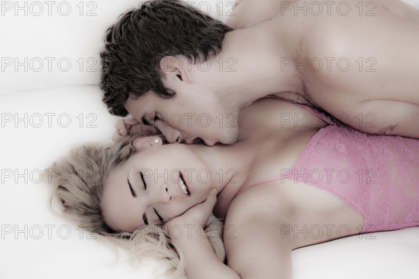 Couple in bed during sex and tenderness. Love and eroticism in the bedroom. Austria