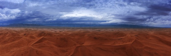 Aerial panorama view on sand dunes with storm clouds at sunset in Gobi Desert, Mongolia, Asia