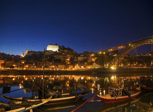 Old town river area of porto in portugal at night with rabelo boats