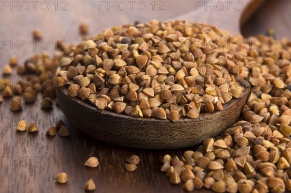 Buckwheat seeds on wooden spoon in closeup, lodz, poland