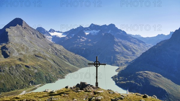 Summit cross on the Bielerkof with views of the Silvretta reservoir, Hohes Rad, Piz Buin and other peaks
