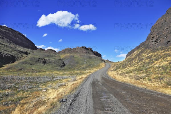 Beautifully curved gravel road between the hills. The National Park Torres del Paine. Chilean Patagonia