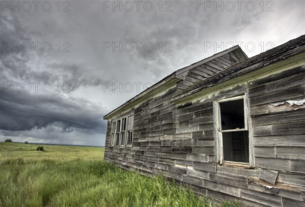 Abandoned Farm with storm clouds in the Canadian Prairie