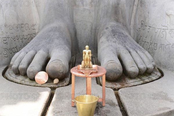 Gomateshwara statue, Jaina-Asket, Jain temple on Vindyagiri Hill, Shravanabelagola, Karnataka, South India, India, Close-up of the feet of a stone statue with a small metal figure in front of it, Mysore, Karnataka, South India, India, Asia