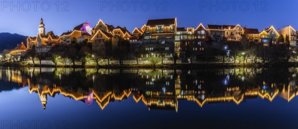 Christmas illuminated house facade of Frohnleiten reflected in the river Mur, panoramic shot, blue hour, Frohnleiten, Styria, Austria, Europe