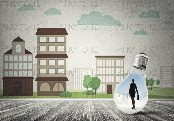 Businesswoman inside light bulb against city drawn concept