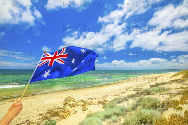 Australian flag waving on the foreground with coastal landscape of Mettams Pool, Trigg Beach, North Beach near Perth in Western Australia. Tourism in Australia, North Beach, Australia, Oceania