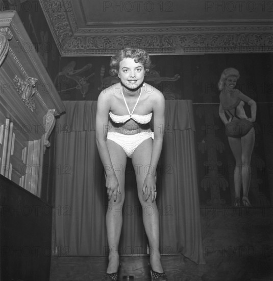 Woman of the 1950s. One of the contestants in the beauty contest is women's hair dresser Lillemor Wahlberg and she is pictured in her bikini during the contest. On the wall behind her is a painting of the american actress Betty Grable, probably the most famous female moviestar during the time of WWII. She was the most popular pin-up girl. Sweden 1953. Kristoffersson ref BL32-10