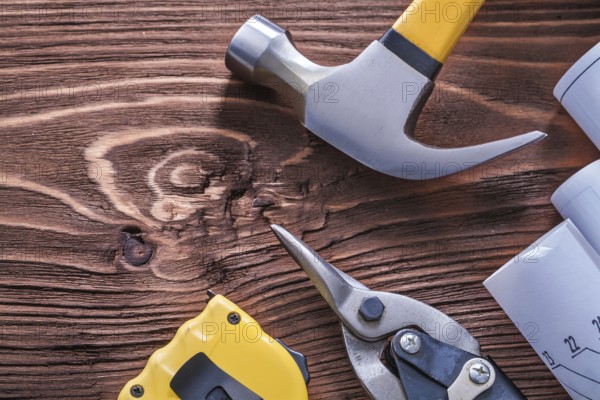 Claw hammer blueprints nippers and tape-measure on wood board construction concept