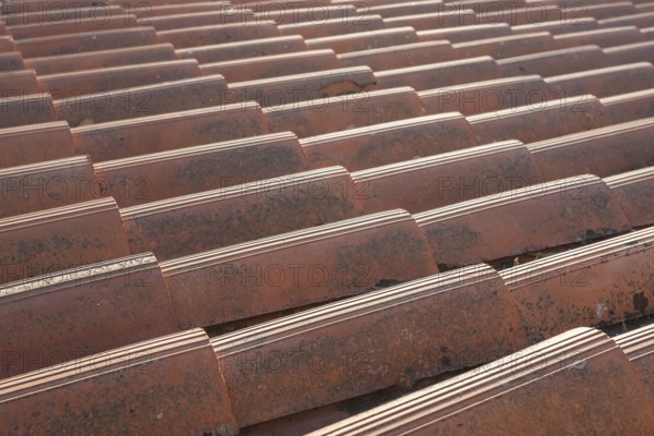 Close up of the red clay roof tiles. Background of old roof