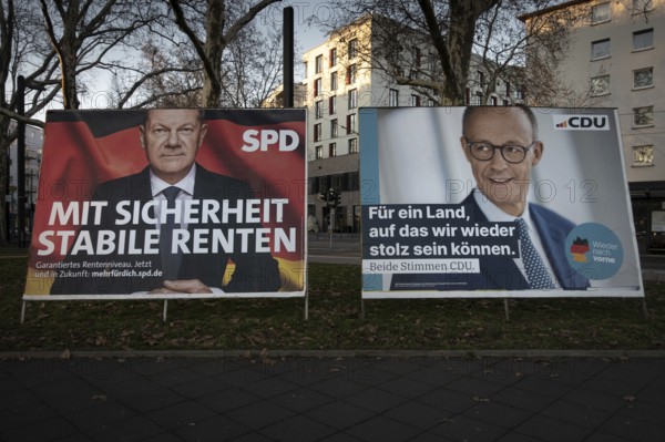 Election posters of the candidates for chancellor Olaf Scholz (SPD, left) and Friedrich Merz (CDU, right) stand on the roadside in Frankfurt am Main. On 23 February 2025, early federal elections will be held in Germany, Frankfurt am Main, Osthafen, Hesse, Germany, Europe