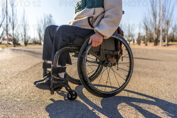 Person using wheelchair enjoying a sunny day in a park, promoting inclusion and accessibility for people with disabilities