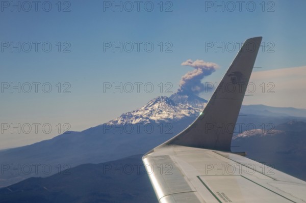 Mexico City, An AeroMexico jet flies past the erupting Popocatepetl volcano