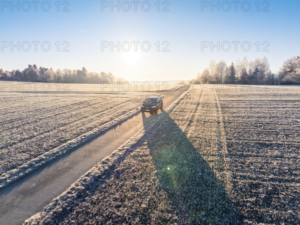 An SUV drives along a frosty country road in the winter morning light, Car Sharing, Electric car, Volkswagen ID 5, Gechingen, Hecken und Gäu Region, Black Forest, Germany, Europe
