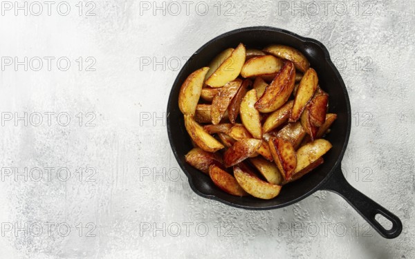 Fried potato slices, in a cast-iron pan, homemade, no people
