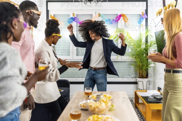 Multi-ethnic friends having fun in a home party dancing and drinking