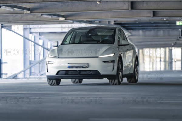 Electric car with modern shapes in a dimly lit car park, Tesla New Model Y Juniper, Calw, Germany, Europe