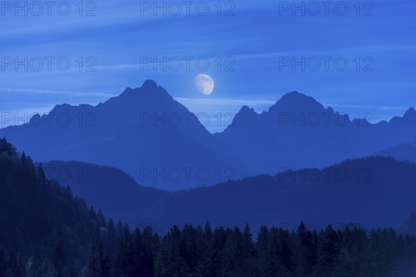 Beautiful mountain landscape at night with shining moon in the background, Schwangau, Ostallgäu, Allgäu, Swabia, Bavaria, Germany, Europe