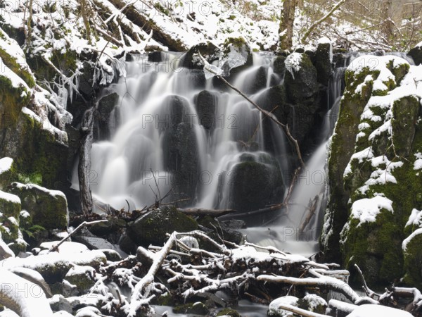 Teufelsmühle waterfall on the hill stream the Schwartzbach, in snow and ice in November. The Rhön UNESCO Biosphere nature reserve, county Bavaria, Germany, Europe