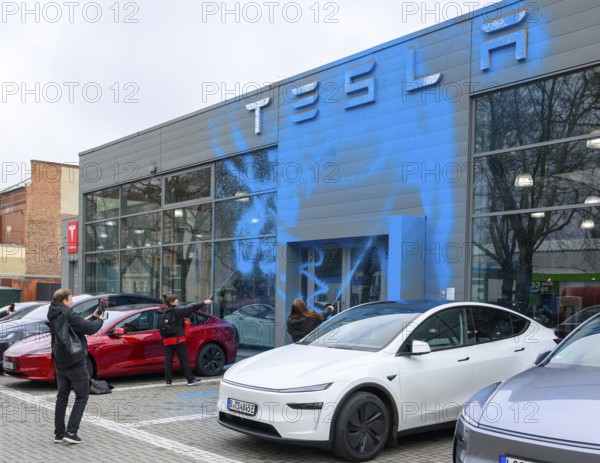 Emma Dorrow and Judith Beadle from the New Generation spray TESLA store with AfD blue paint. Tesla Centre in Berlin Reinickendorf, 31.03.2025