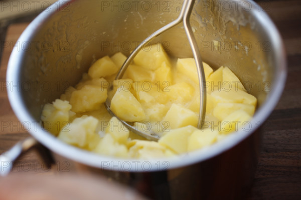 Swabian cuisine, preparation of beef roulade with pine nuts, making mashed potatoes, potato masher, boiled potato pieces in cooking pot, grandmother's kitchen, regional, home cooking, typical Swabian, traditional cuisine reinterpreted, food photography, studio, Germany, Europe