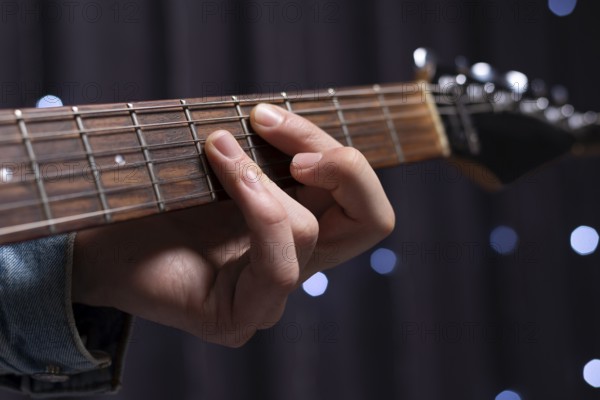 Image of the hands of a musician playing the electric guitar. The concept of concerts and entertainment events.
