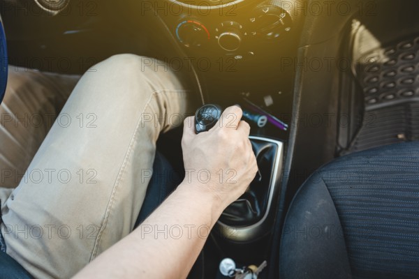 Driver hand grabbing car gear stick, closeup of hands accelerating on gear stick. Close-up of driver hand on the gear lever of a car