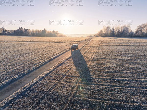 A vehicle on a frost-covered road in the rural sunrise, car sharing, electric car, Volkswagen ID 5, Gechingen, Hecken und Gäu region, Black Forest, Germany, Europe