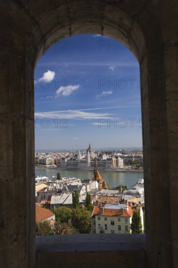 Budapest city skyline with Danube river and Hungarian parliament through stone arch in summer, Hungary, Europe
