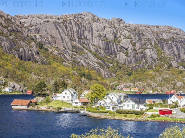 Steep granite mountains at the sea near Ana Sira, village Stornes, typcial coastal village, at coastal road 44 between Kristiansand and Egersund, southern Norway