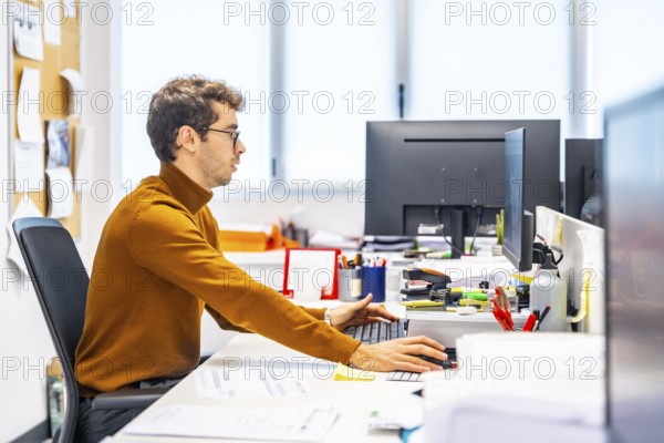 Enigneer using computer to design a metal piece in a cnc factory