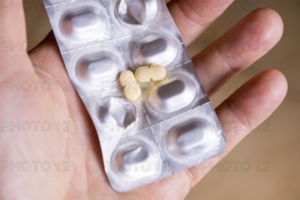 Hand holding a blister pack with tablets