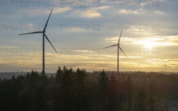 Wind turbines against a golden sky at the edge of a forest at sunrise, Rems Valley, Baden-Württemberg, Germany, Europe